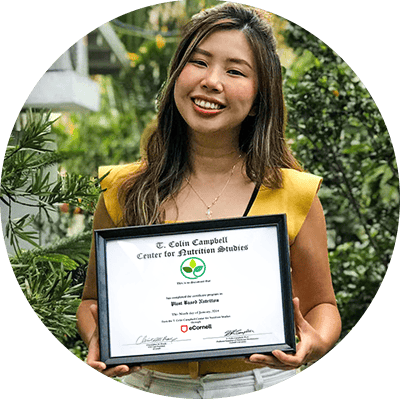 Student posing with their Plant-Based Nutrition Certificate